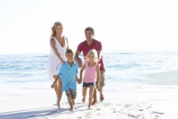 Famiglia felice che corre sulla spiaggia.